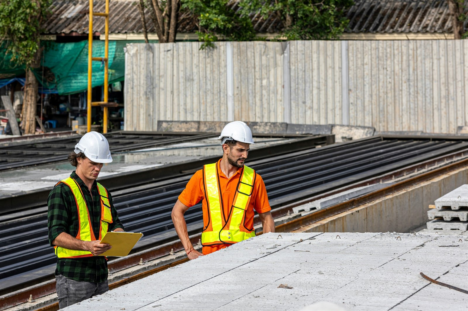 Engineers reviewing drawings beside precast concrete units